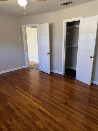 an empty room with wooden floor and closet