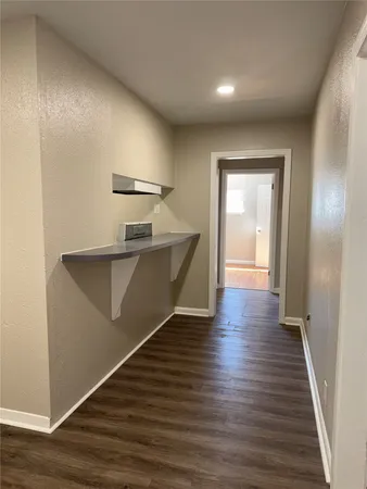 a view of a hallway with wooden floor