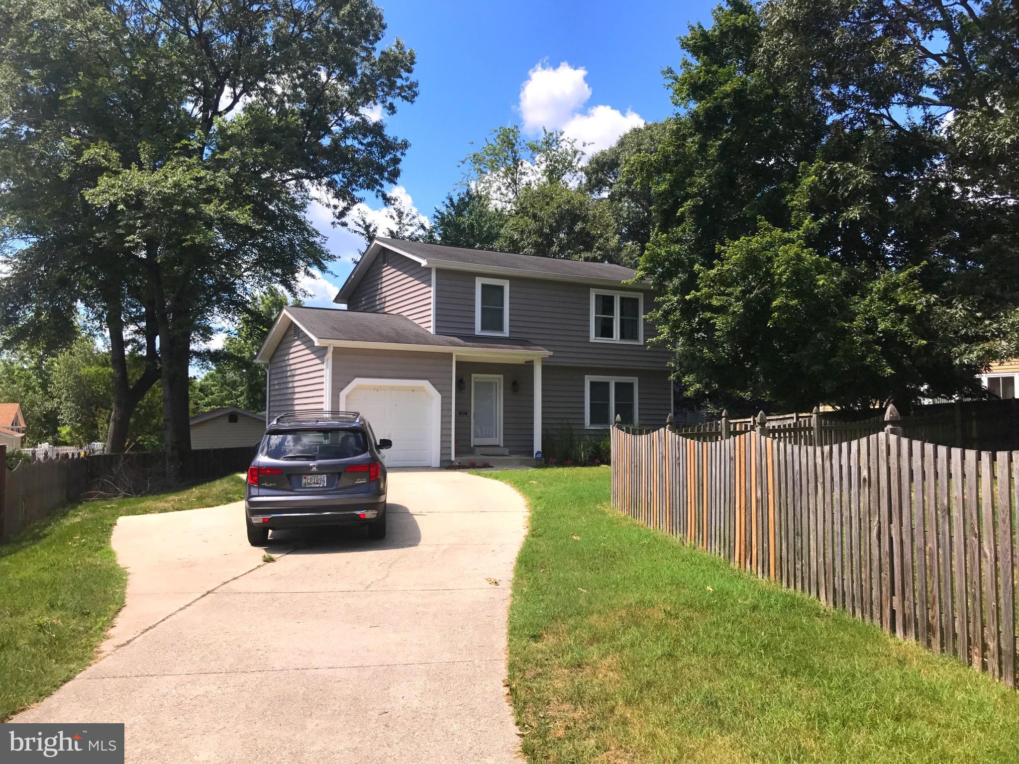 2897 Dungate Road Pasadena, MD 21122 - Photo 3 of 30 a front view of a house with a garden and trees