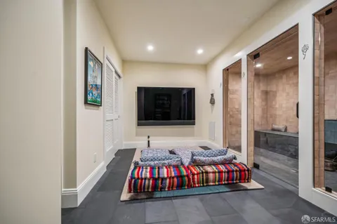 a living room with a large bed and a flat screen tv