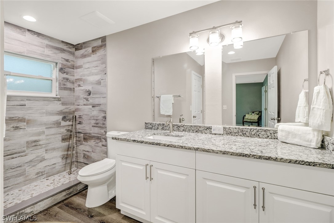 112 Rowland Road Lehigh Acres, FL 33936 - Photo 12 of 22 a bathroom with a granite countertop sink toilet and mirror