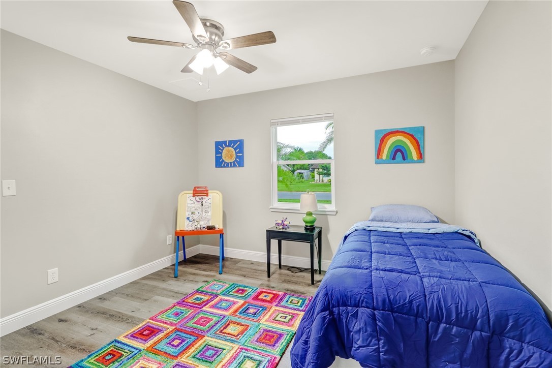 112 Rowland Road Lehigh Acres, FL 33936 - Photo 13 of 22 a bedroom with a bed and a chandelier