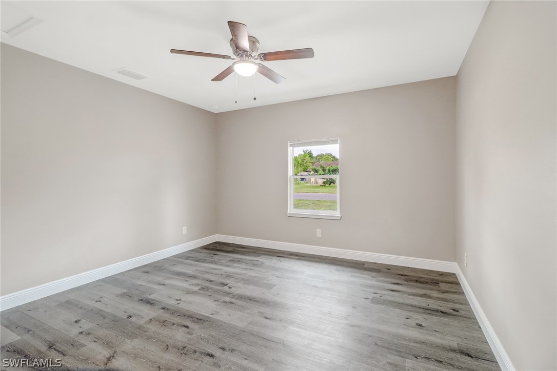 112 Rowland Road Lehigh Acres, FL 33936 - Photo 15 of 22 an empty room with wooden floor and windows