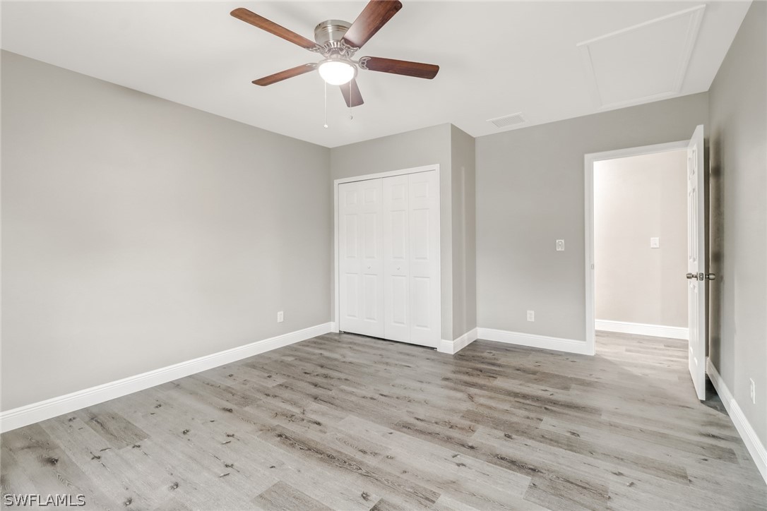 112 Rowland Road Lehigh Acres, FL 33936 - Photo 16 of 22 an empty room with wooden floor ceiling fan and window