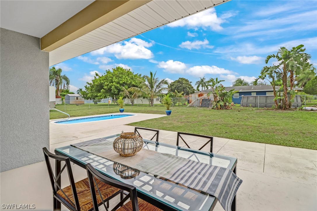 112 Rowland Road Lehigh Acres, FL 33936 - Photo 18 of 22 a view of a patio with table and chairs and a yard