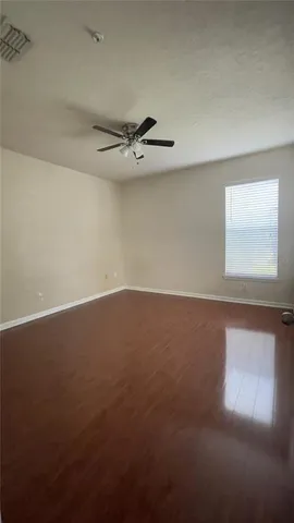 en empty room with windows and ceiling fan