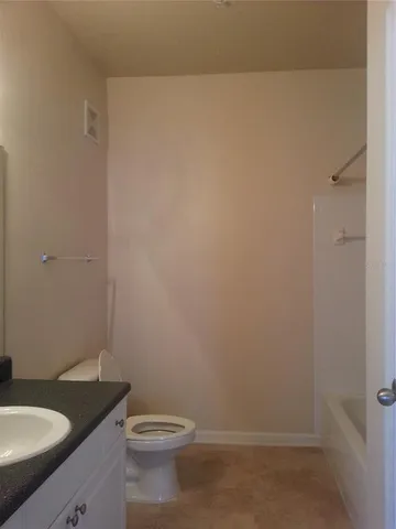 a bathroom with a granite countertop toilet and sink