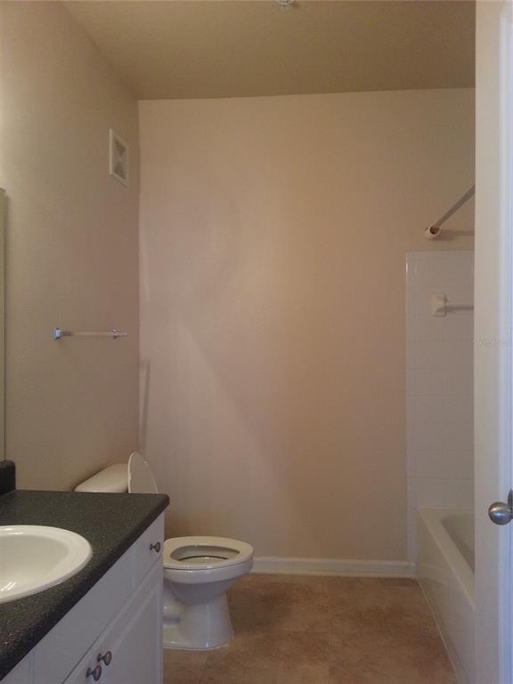 8849 Villa View Circle, Unit 206 Orlando, FL 32821 - Photo 14 of 19 a bathroom with a granite countertop toilet and sink