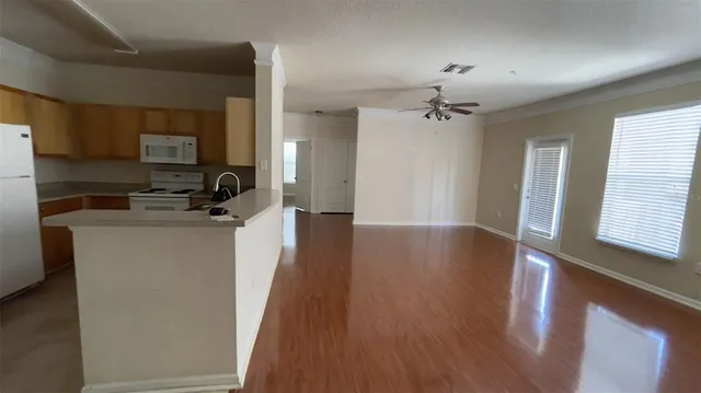 a view of a kitchen with a sink wooden floor and a window