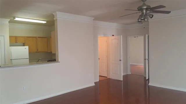 a view of a room with a chandelier fan and wooden floor
