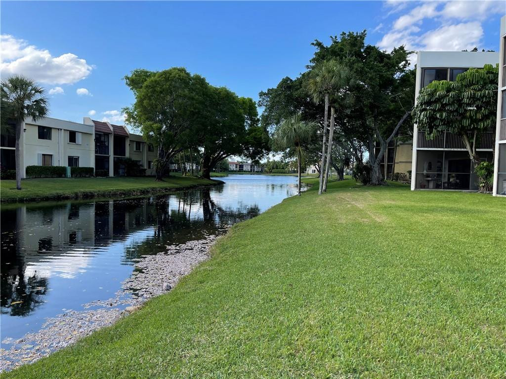 491 Racquet Club Road, Unit 109 Weston, FL 33326 - Photo 12 of 39 a view of a patio with table and chairs potted plants and large tree