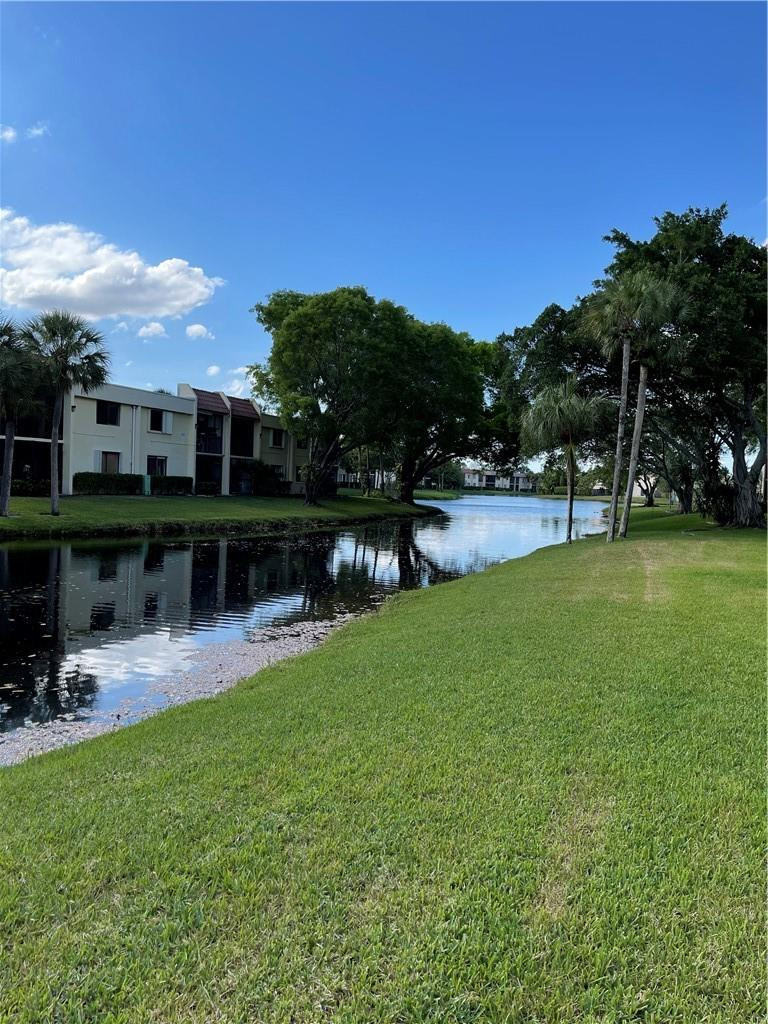 491 Racquet Club Road, Unit 109 Weston, FL 33326 - Photo 13 of 39 a view of a lake with a garden and plants