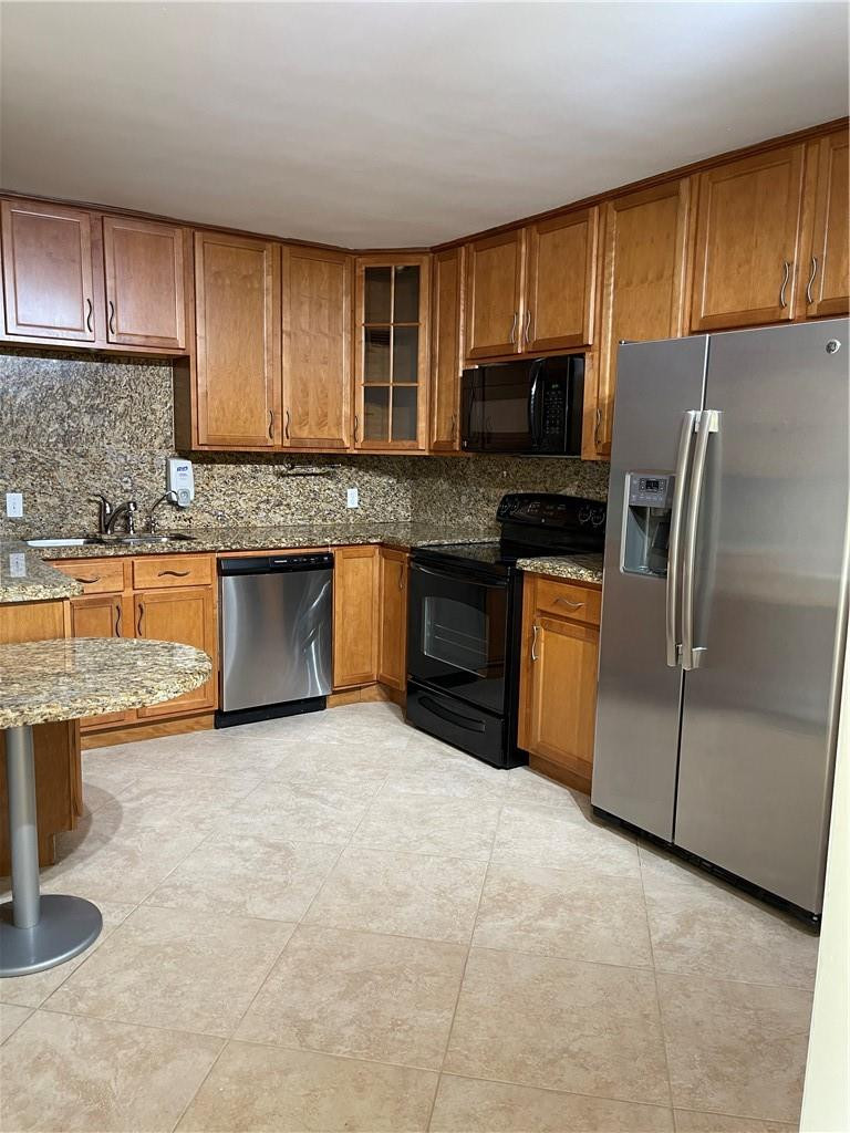 491 Racquet Club Road, Unit 109 Weston, FL 33326 - Photo 29 of 39 a kitchen with stainless steel appliances granite countertop a stove top oven a sink dishwasher a refrigerator and cabinets with wooden floor