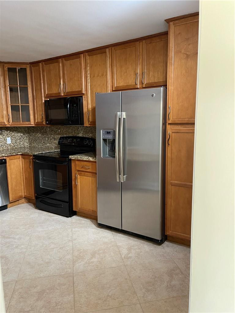 491 Racquet Club Road, Unit 109 Weston, FL 33326 - Photo 31 of 39 a kitchen with granite countertop a refrigerator and a stove top oven