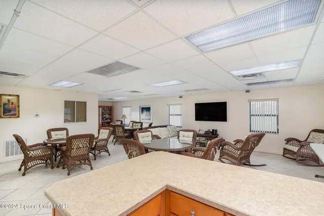 a living room with furniture a flat screen tv and kitchen view