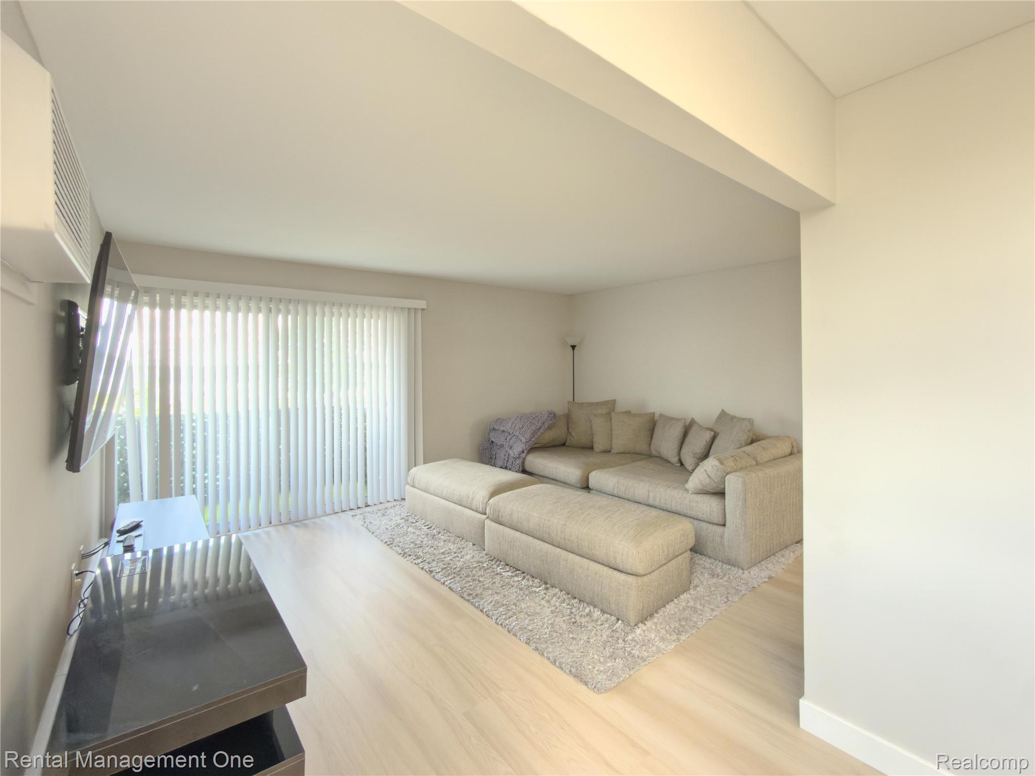 1603 Cass Lake Road, Unit D Keego Harbor, MI 48320 - Photo 12 of 20 Luminous living area featuring light wood-finish flooring and neutral wall tones