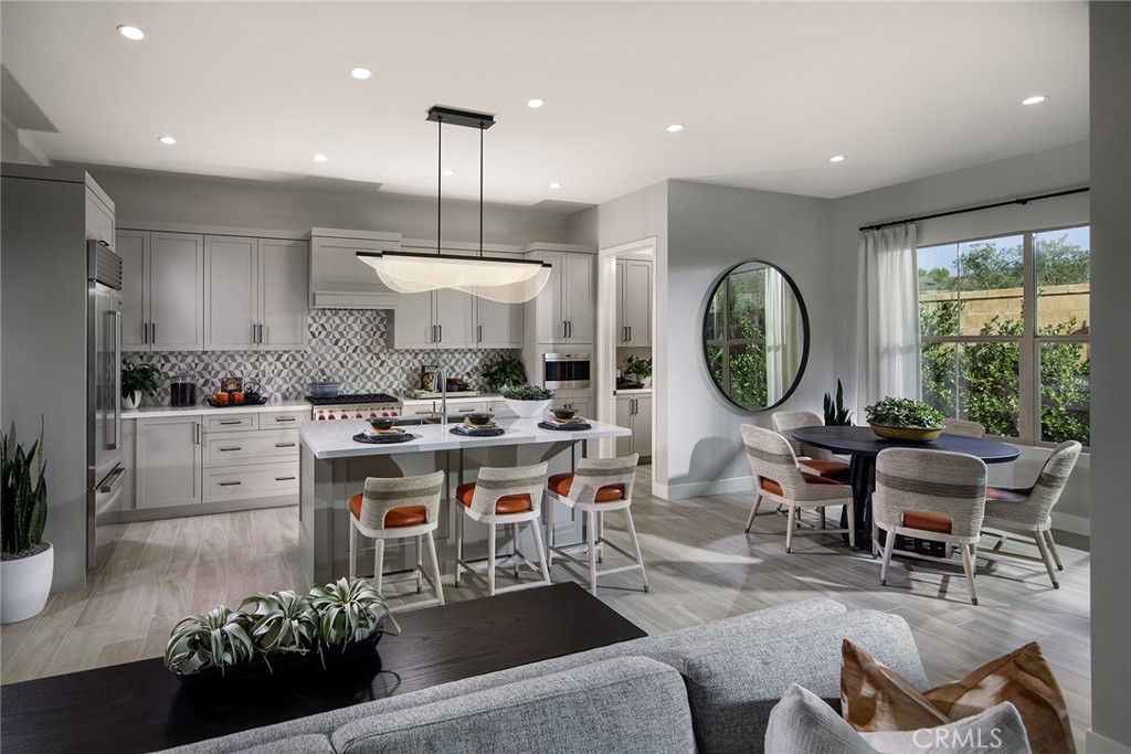 a kitchen with stainless steel appliances kitchen island granite countertop a stove a sink a dining table and chairs