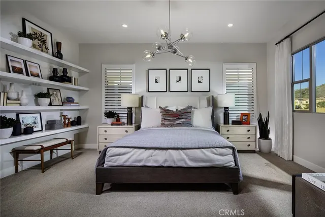 a bedroom with a large bed and a chandelier