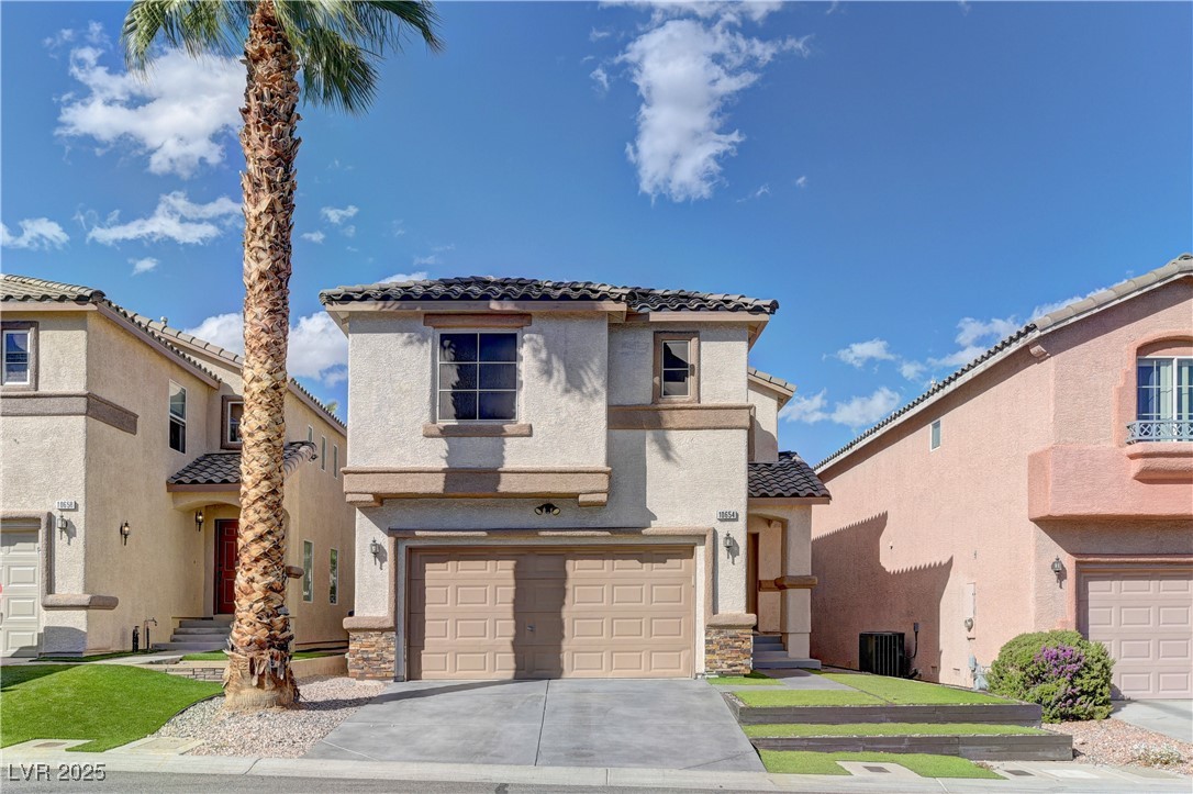 Mediterranean / spanish home with a tile roof, stucco siding, concrete driveway, a garage, and stone siding