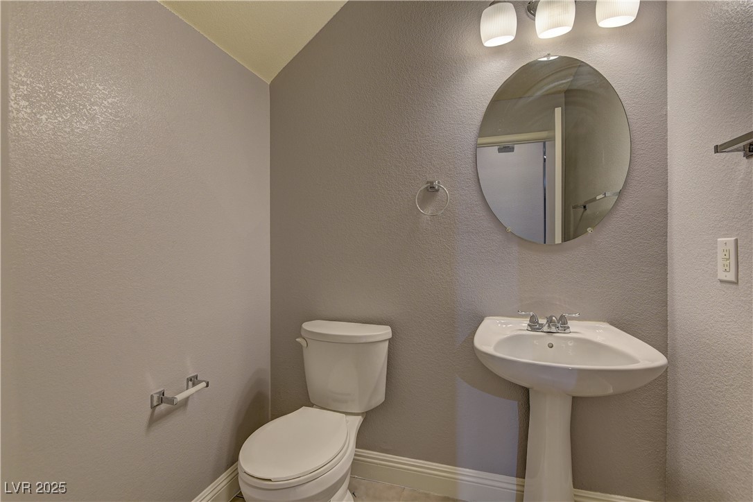 10654 Solar Hawk Avenue Las Vegas, NV 89129 - Photo 14 of 26 Half bath with a textured wall and lofted ceiling