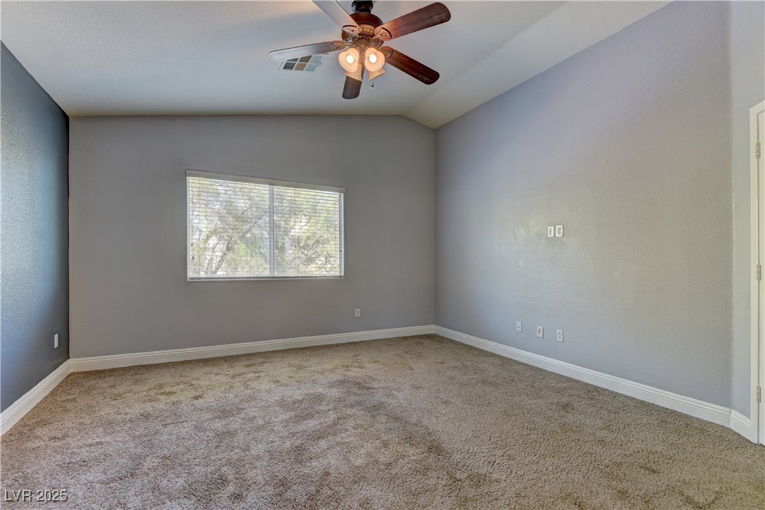10654 Solar Hawk Avenue Las Vegas, NV 89129 - Photo 18 of 26 Unfurnished room featuring light carpet, ceiling fan, and lofted ceiling