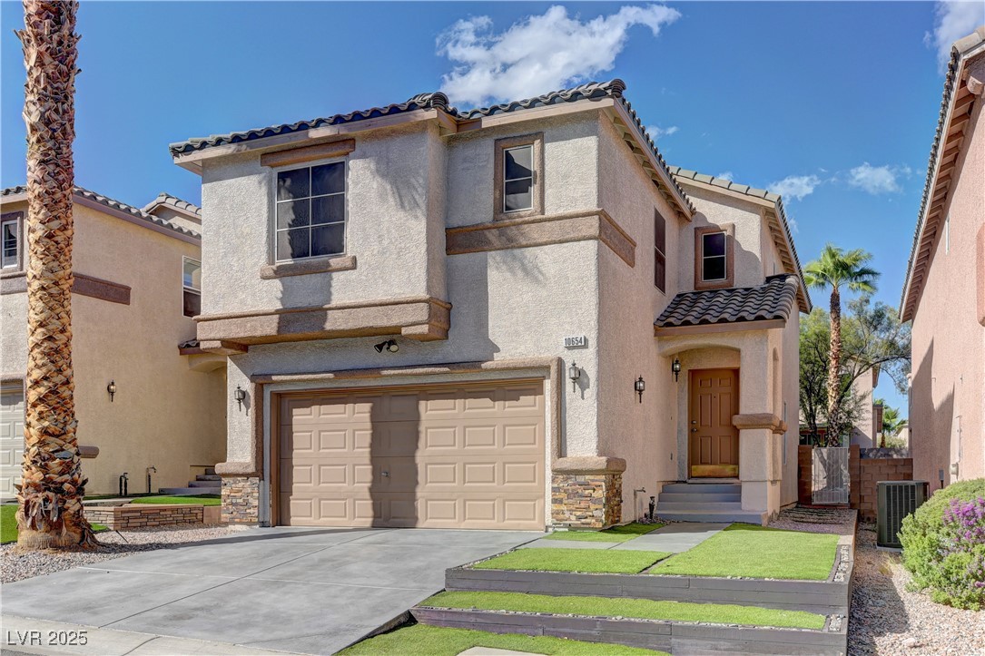10654 Solar Hawk Avenue Las Vegas, NV 89129 - Photo 2 of 26 Mediterranean / spanish-style home featuring stucco siding, a tiled roof, concrete driveway, and an attached garage