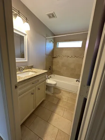 a bathroom with a granite countertop sink mirror and a bathtub