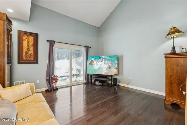 a living room with furniture and a flat screen tv with wooden floor