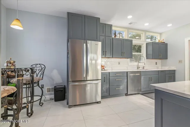 a kitchen with stainless steel appliances a refrigerator sink and microwave
