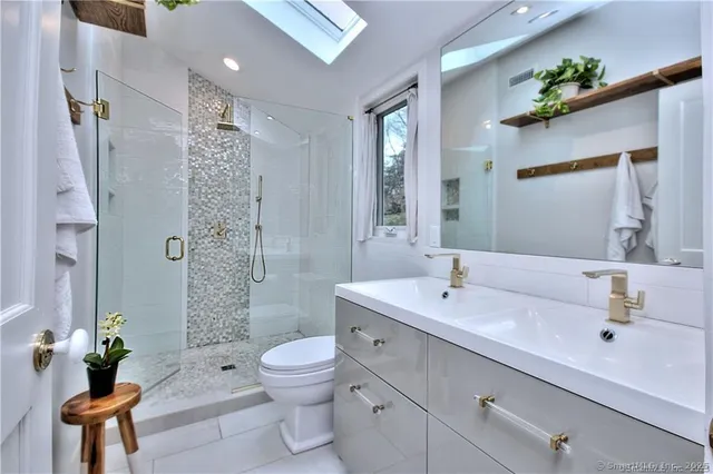 a bathroom with a sink a toilet and shower