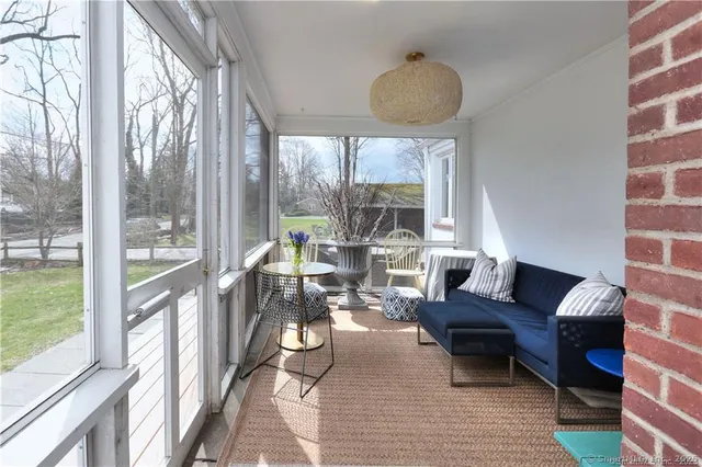 a living room with furniture and a floor to ceiling window