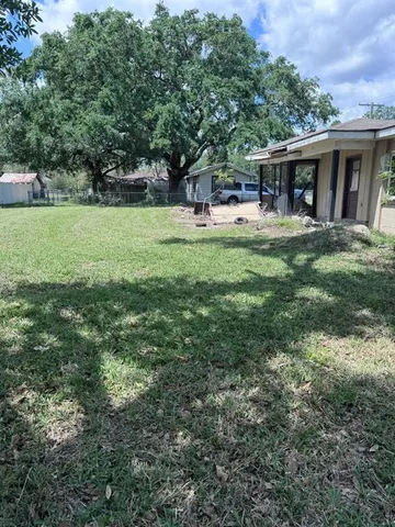 a front view of house with yard and trees in the background