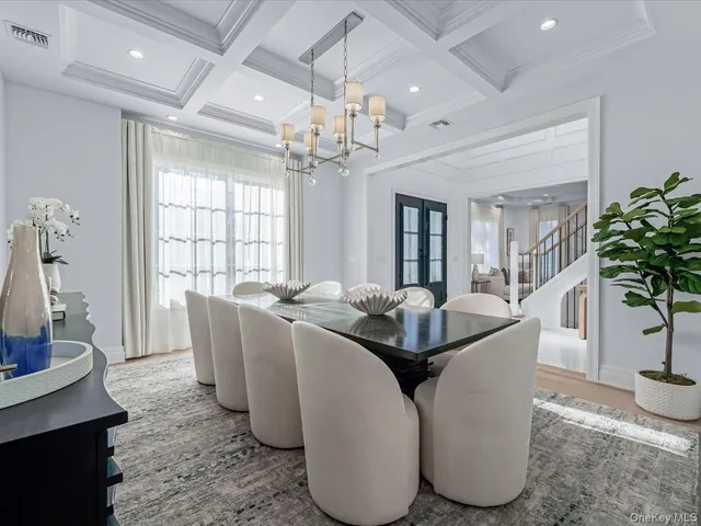 a living room with furniture a chandelier and a dining room