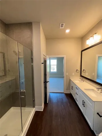 a bathroom with a double vanity sink and mirror with shower