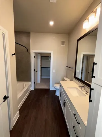 a bathroom with a double vanity sink a mirror and a bathtub