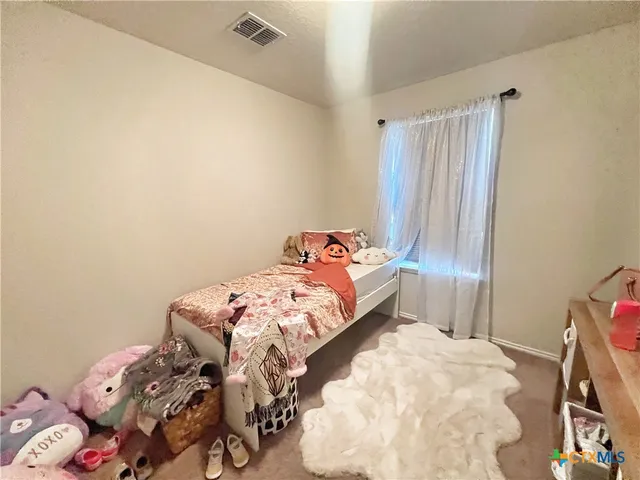 a bed sitting in a bedroom next to a window