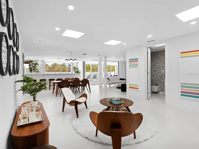 a large white kitchen with a large counter top a sink a stove and a refrigerator