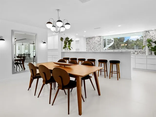 a dining room with furniture and a floor to ceiling window