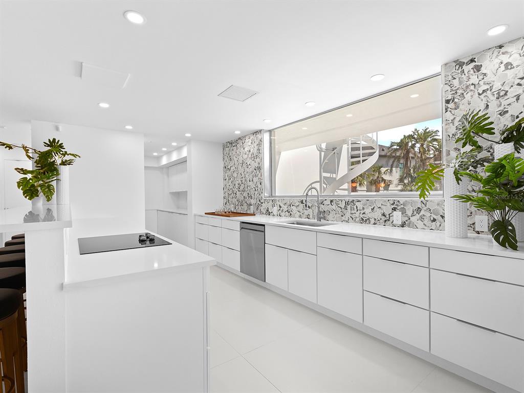 7647 Sanderling Road Sarasota, FL 34242 - Photo 22 of 75 a kitchen with granite countertop a sink and white cabinets