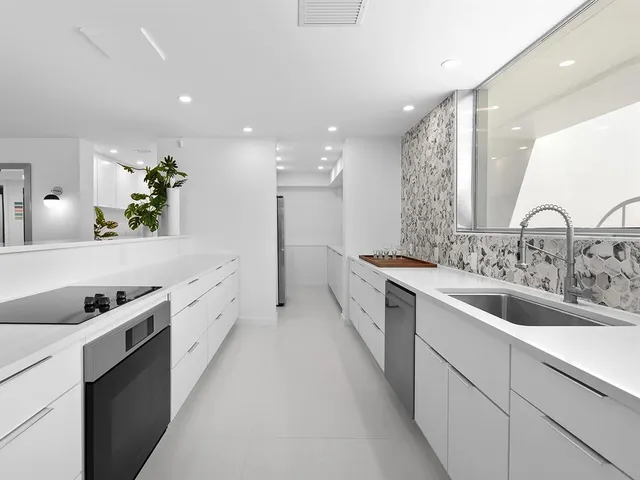 a bathroom with a sink a vanity and a potted plant