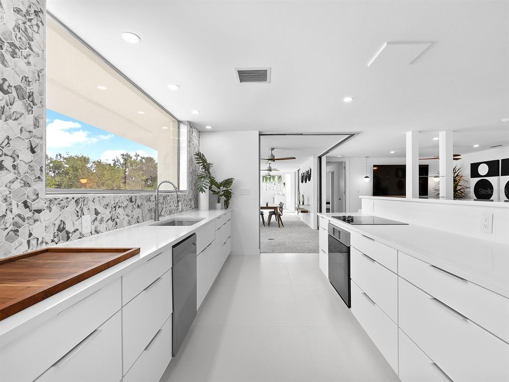 7647 Sanderling Road Sarasota, FL 34242 - Photo 26 of 75 a large white kitchen with a large window