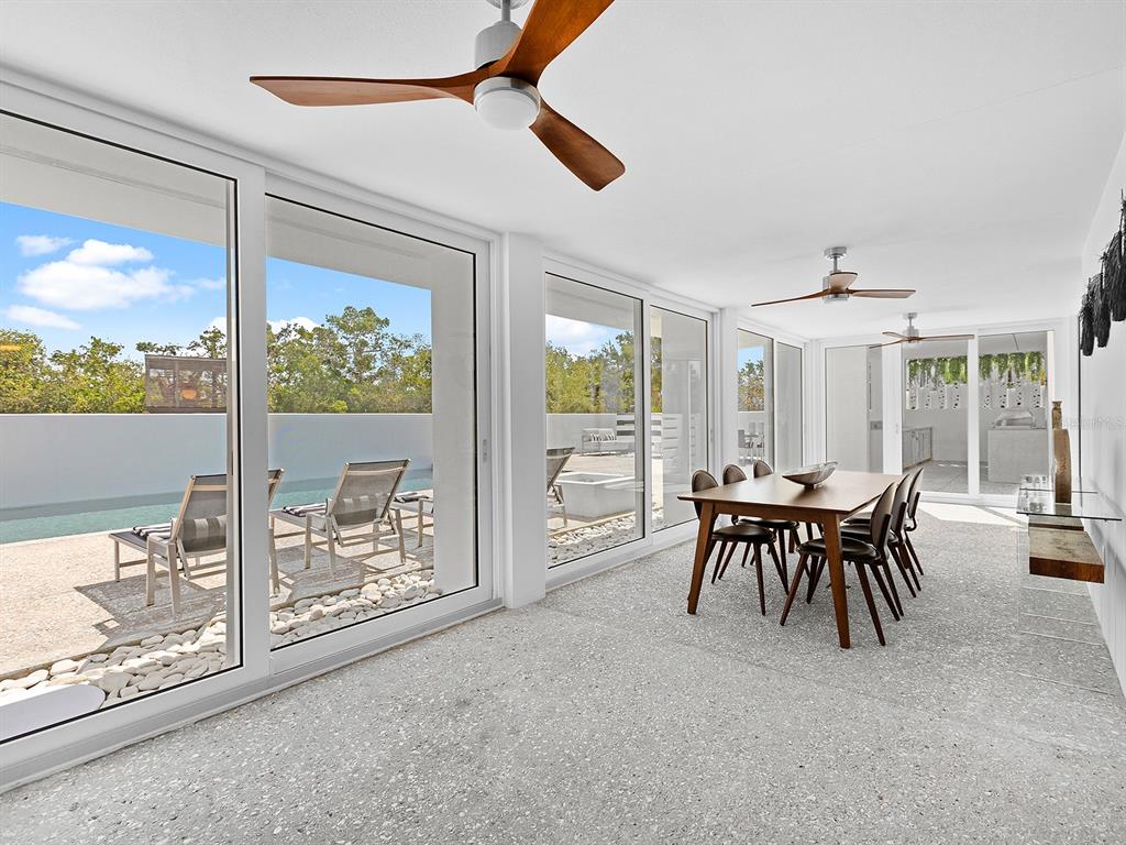 7647 Sanderling Road Sarasota, FL 34242 - Photo 27 of 75 a dining room with furniture and a floor to ceiling window