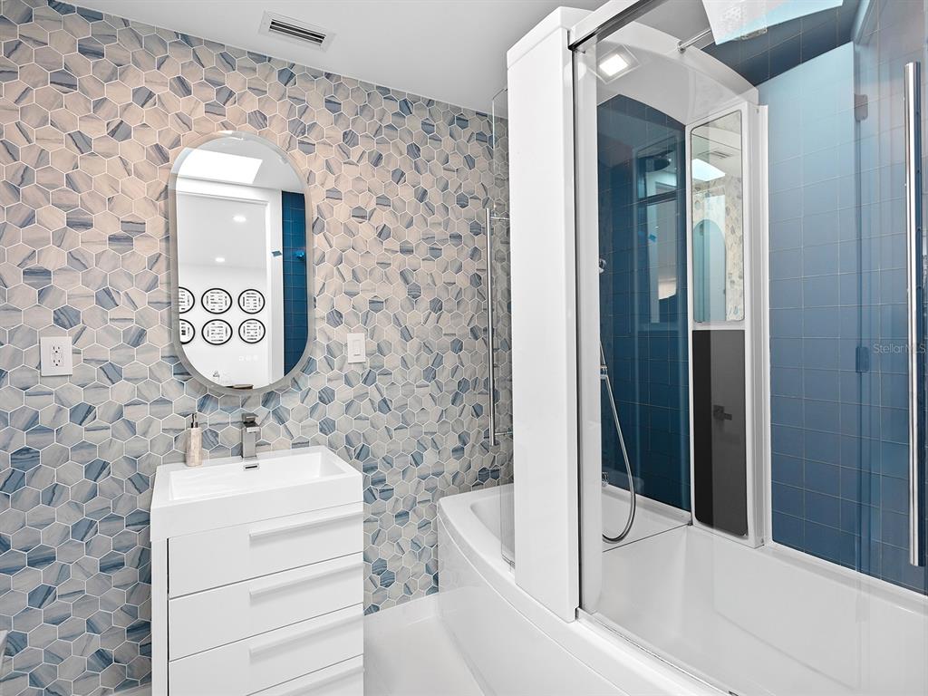 7647 Sanderling Road Sarasota, FL 34242 - Photo 41 of 75 a bathroom with a sink and a mirror