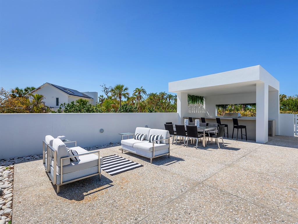 7647 Sanderling Road Sarasota, FL 34242 - Photo 47 of 75 a outdoor living space with furniture and a potted plant