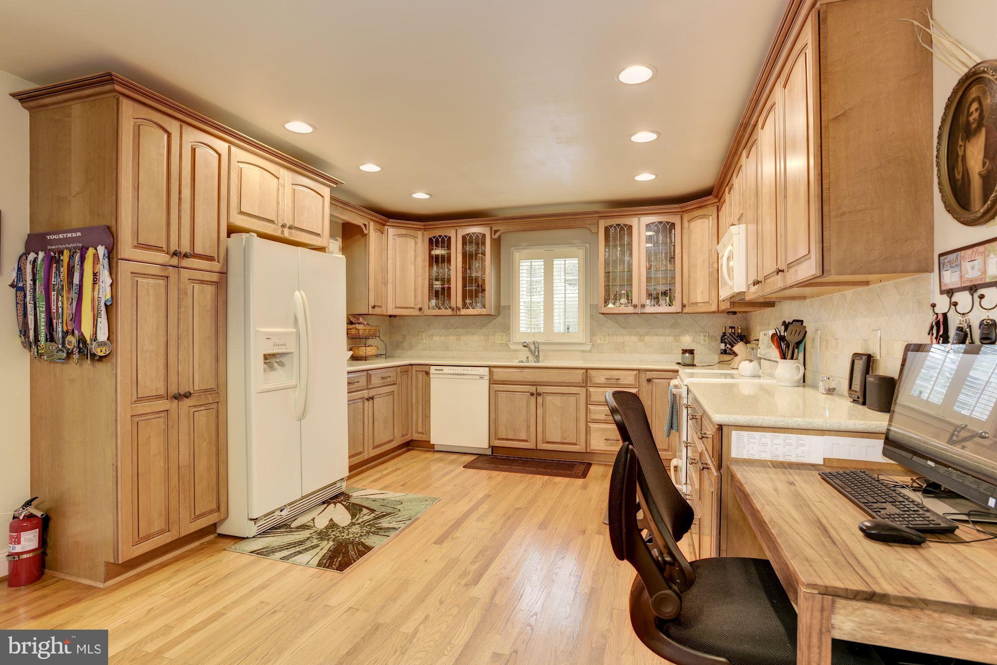 306 Homewood Road Linthicum, MD 21090 - Photo 3 of 32 a kitchen with stainless steel appliances kitchen island granite countertop a refrigerator a sink a stove and white cabinets with wooden floor