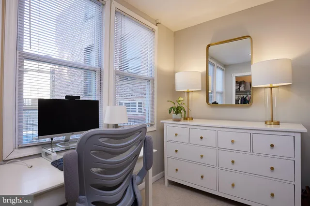 a bathroom with a sink a mirror and a chair