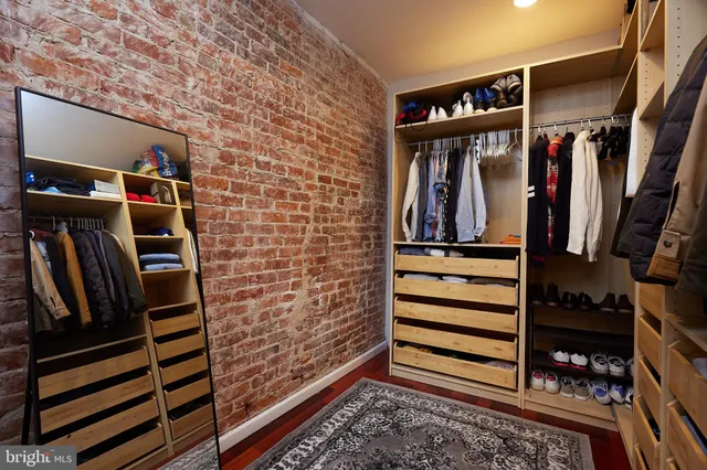 a view of walk in closet with clothes and shoes