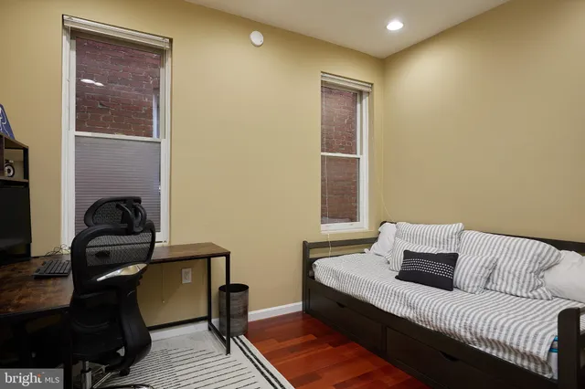 a bedroom with a bed and wooden floor