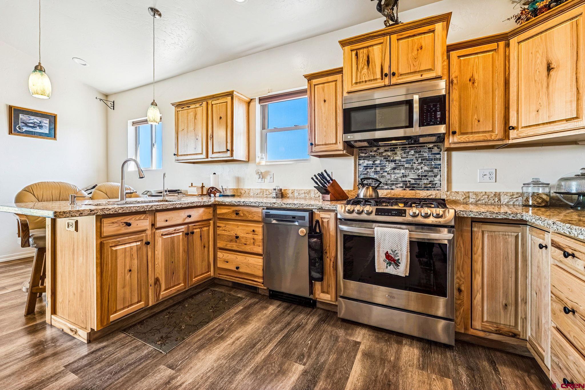 64 Summer Lane Durango, CO 81303 - Photo 18 of 25 a kitchen with stainless steel appliances granite countertop a stove a sink dishwasher and microwave oven with cabinets