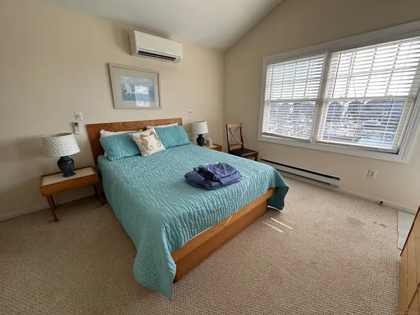 a bedroom with a bed and a couch next to a window